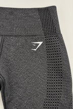 Close-up of white Gymshark logo and seamless knit pattern on grey leggings